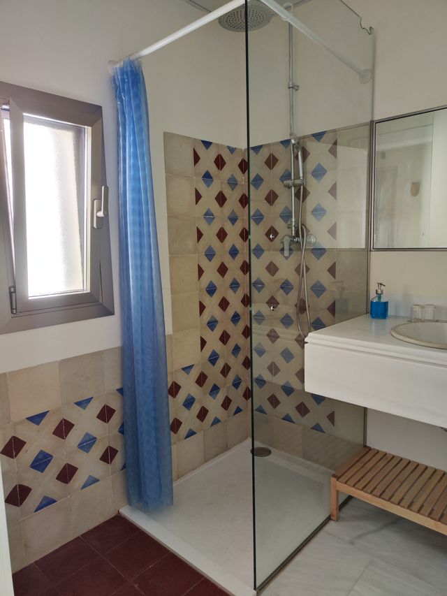 Baño completo con ducha de mampara, lavabo y alicatado de baldosa artesanal