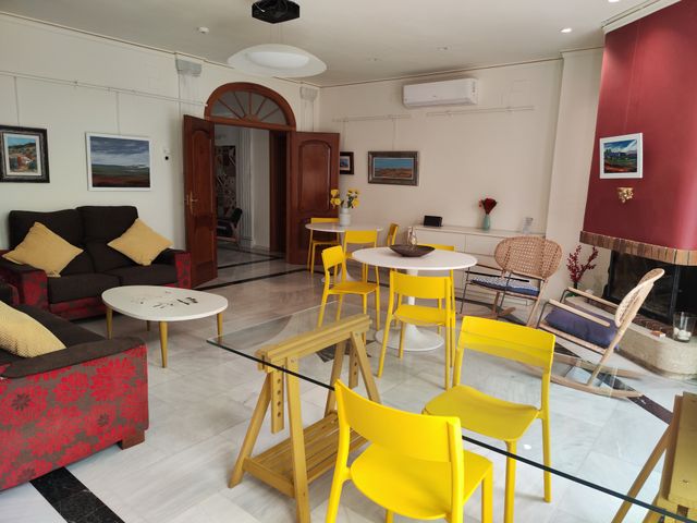 Vista del salón con sofás, zona de comedor y la puerta de madera en arco al fondo