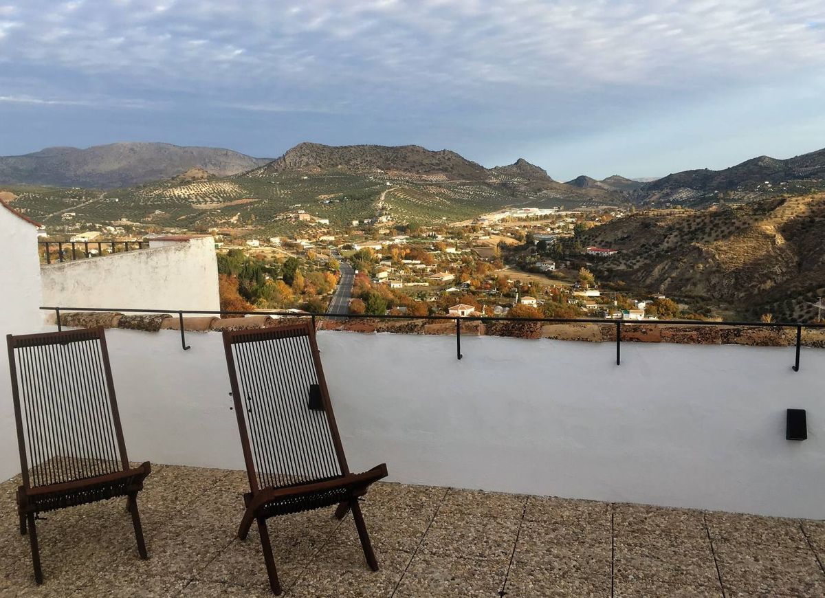 Terraza con sillas de madera y vistas a Priego de Córdoba, la vega y las sierras
